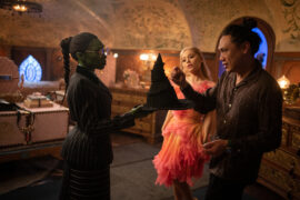 Cynthia Erivo (als Elphaba) und Ariana Grande (als Glinda) mit Regisseur Jon M. Chu am Set von WICKED.